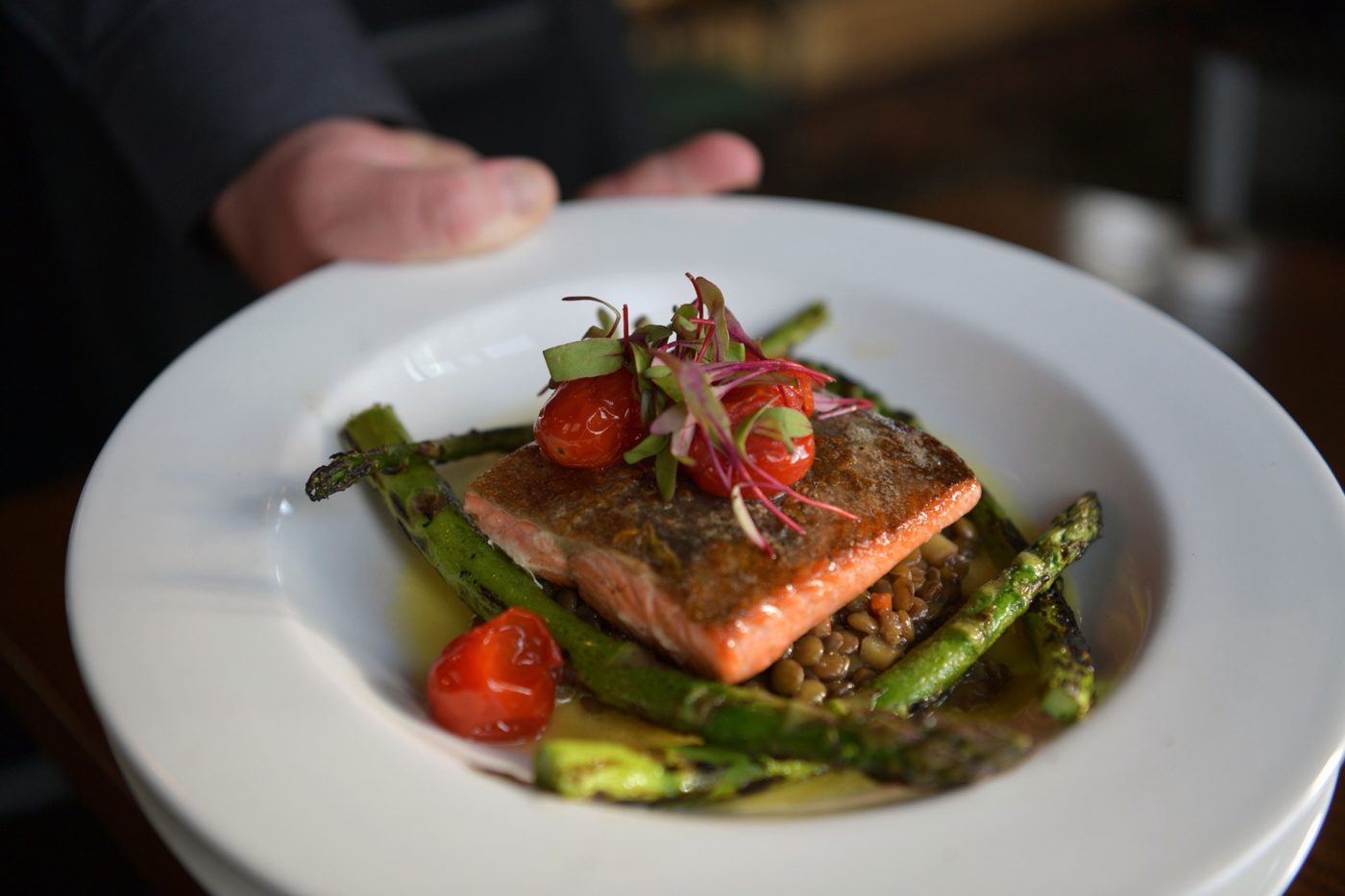 Seared salmon on lentils with grilled asparagus and roasted tomatoes
